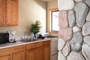 eine Küche mit einer Felswand neben einer Spüle in der Unterkunft 2401 - Oak Knoll Studio with Jacuzzi #2 cabin in Big Bear Lake