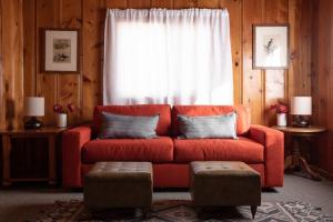 a living room with a red couch in front of a window at 2400-Oak Knoll Lodge cabin in Big Bear Lake