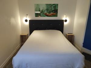 a bedroom with a white bed with two lights on it at FASTHOTEL PARIS OUEST BOUAFLE in Bouafle +28 photos