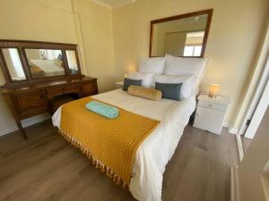 1 dormitorio con 1 cama grande y espejo en Sunset Haven: Mountain Views & Office Space, en Ciudad del Cabo