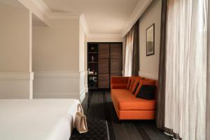 een slaapkamer met een bed en een bank bij Palazzo Navona Hotel in Rome