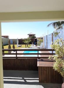 uma varanda com uma cerca e uma piscina em Pousada Ingleses Beach em Florianópolis
