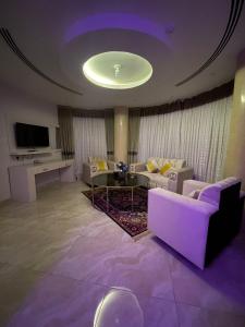 un ampio soggiorno con illuminazione viola e soffitto viola di Rayat Al Shalal Hotel a Hafr Al Baten