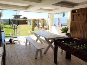 Pousada Ingleses Beach في فلوريانوبوليس: طاولة تنس طاولة ومقعد في ساحة
