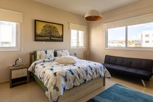 een slaapkamer met een bed, een bank en ramen bij Central Bliss / your perfect home away from home in Limassol