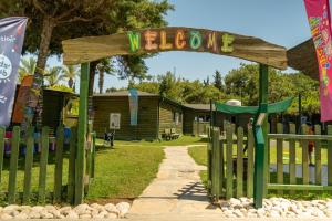 a welcome sign in front of a wooden fence at AQI Pegasos Resort in Avsallar