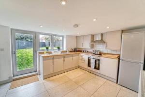 cocina con electrodomésticos blancos y ventana grande en Guest Homes - Bridge Street Dwelling, en Leominster