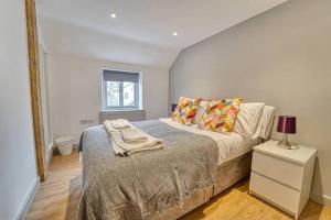 1 dormitorio con cama y mesita de noche con lámpara en Guest Homes - Bridge Street Dwelling, en Leominster
