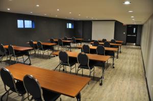 ein Klassenzimmer mit Tischen, Stühlen und einem Whiteboard in der Unterkunft Residence & Conference Centre - Kitchener-Waterloo in Kitchener