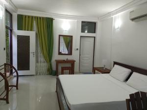 una camera con un grande letto bianco e una sedia di Habarana Spice Village Hotel & Restaurant a Moragaswewa