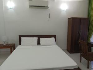 ein Schlafzimmer mit einem großen Bett und einem Stuhl in der Unterkunft Habarana Spice Village Hotel & Restaurant in Moragaswewa