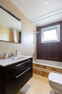 a bathroom with a sink and a toilet and a window at Central Bliss / your perfect home away from home in Limassol +57 photos
