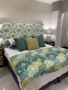 a bedroom with a large bed with a colorful bedspread at On the Beach in Durban
