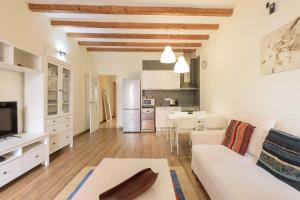 a living room with a white couch and a table at Lodging Apartments Gracia in Barcelona