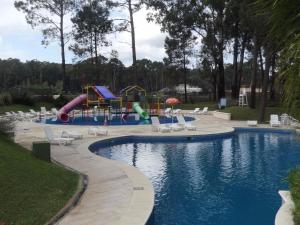 a swimming pool with a slide and a playground at Solanas Green park resort and spa Vacation Club in Punta del Este