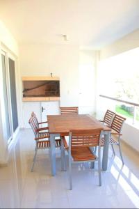 uma sala de jantar com uma mesa de madeira e cadeiras em Solanas Green park resort and spa Vacation Club em Punta del Este