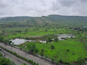 an aerial view of a field and a river at Zoey's Hill View - 120" 4K Projection Cinema, Jacuzzi, Party Up in Navi Mumbai