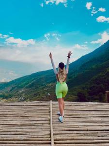 a woman in a yellow bikini standing on top of a mountain at Traditional Wooden house & trekking adventure in Sa Pa