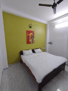 łóżko w pokoju z zieloną ścianą w obiekcie Ganga Putra Inn w mieście Waranasi