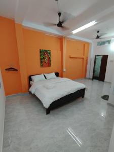 a bedroom with orange walls and a large bed at Ganga Putra Inn in Varanasi