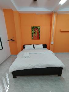 a bedroom with a large bed with orange walls at Ganga Putra Inn in Varanasi