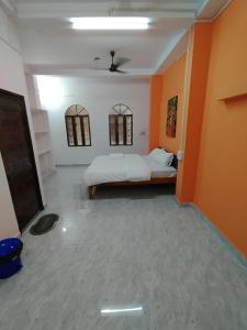 a bedroom with a bed in a room with orange walls at Ganga Putra Inn in Varanasi
