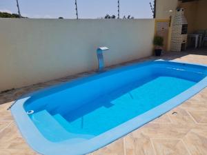 ein großer blauer Pool mit einem Wasserhahn in der Unterkunft Chalés Sons do Mar in Barra do Cunhau