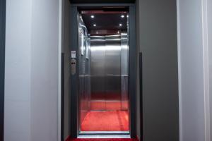 un ascensor con alfombra roja en un pasillo en Pucci Bärengarten Stadthotel, en Ravensburg