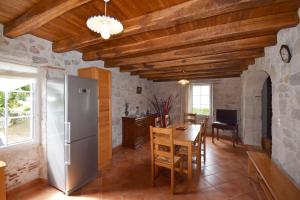 een keuken en eetkamer met een koelkast en een tafel bij Ancienne ferme restaurée à Perville, Tarn-et-Garonne in Perville