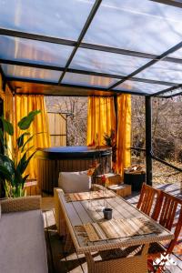 a patio with a table and chairs and a tub at Gipsy Village Park Hotel in Asuretʼi