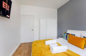 a bedroom with a white bed with towels on it at Henry Court Apartment 4 in York