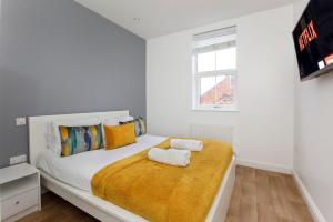 a white bedroom with a large bed with two towels at Henry Court Apartment 4 in York
