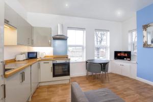 a kitchen with white cabinets and a table at Henry Court Apartment 4 in York