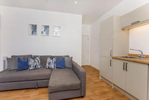 a living room with a couch and a kitchen at Henry Court Apartment 4 in York