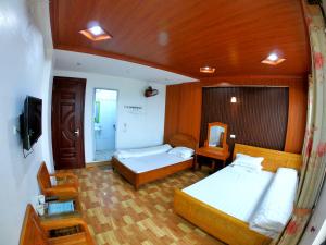 a large room with two beds and a television at Minh Hưng Hostel in Sa Pa