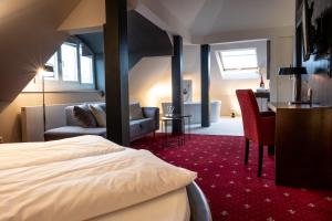 una camera d'albergo con letto e scrivania di Pucci Bärengarten Stadthotel a Ravensburg