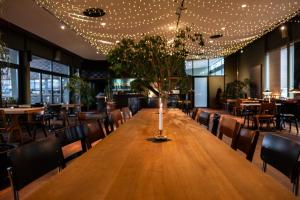Pucci Bärengarten Stadthotel في رافنسبرغ: طاولة خشبية طويلة في مطعم مع كراسي