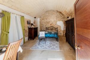 a living room with a table and a stone wall at La Dimora delle Grazie in San Cesario di Lecce