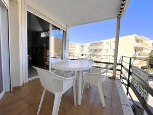 - Balcón con mesa blanca y sillas en Salida directa al Paseo Marítimo de La Horta 110B - INMO22, en Cambrils