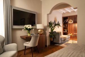 Schlafzimmer mit einem Bett und einem Schreibtisch mit einem TV in der Unterkunft Antico Albergo del Sole al Pantheon in Rom
