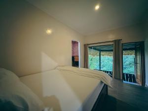 ムンドゥックにあるMunduk Tutub waterfall viewのベッドルーム(白いベッド1台、窓付)