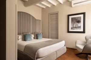 a bedroom with a large bed and a chair at Antico Albergo del Sole al Pantheon in Rome