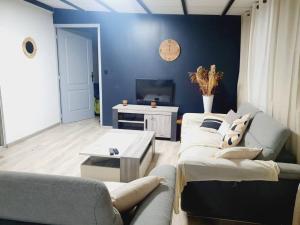 uma sala de estar com dois sofás e uma televisão em Sweet metykaz em Le Tampon