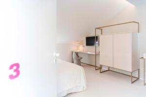a white bedroom with a white bed and a mirror at Fonda Llabres Boutique in Alcudia
