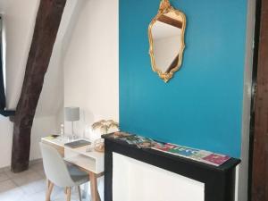 een spiegel aan een muur naast een tafel bij Splendide Moulins in Moulins