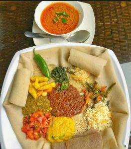 una bandeja de comida con frijoles y un tazón de sopa en King Dawit Ethiopia Tours & Travel en Addis Abeba