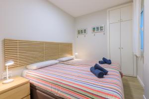 a bedroom with a bed with two blue pillows on it at Stay Barcelona Rossello in Barcelona