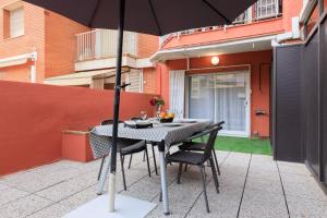 a table and chairs with an umbrella on a patio at Stay Barcelona Rossello in Barcelona