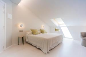 a white bedroom with a bed and a window at Fonda Llabres Hostal Boutique in Alcudia