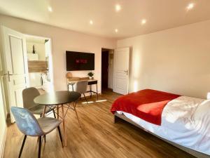 een slaapkamer met een bed, een tafel en een bureau bij Charmant studio + parking privé in Caen